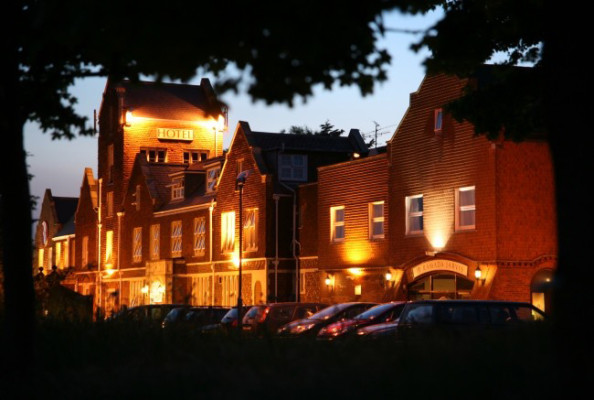 Exterior of large brick building, with lights.