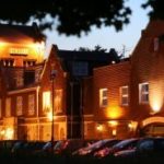 Exterior of large brick building, with lights.