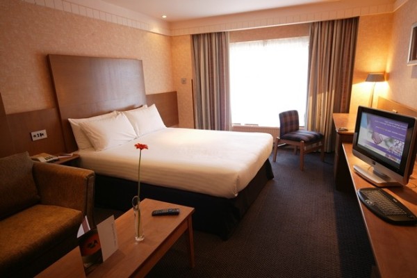 Hotel bedroom with double bed and tv.