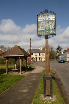 Bus shelter left, Rowledge village sign, pub in background