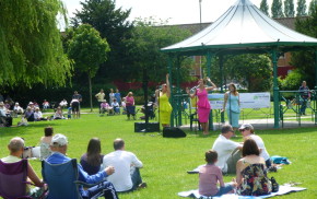 People watching three female singers at Music in the Meadow. © Farnham Town Council