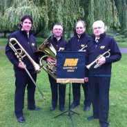 Four male members of brass band. Music stand. Brass instruments.