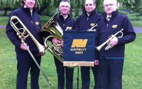 Four male members of brass band. Music stand. Brass instruments.