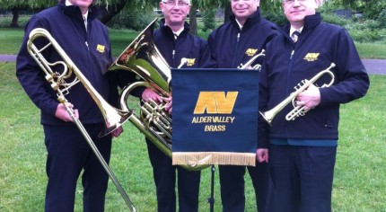 Four male members of brass band. Music stand. Brass instruments.