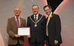 Three males holding certificate.