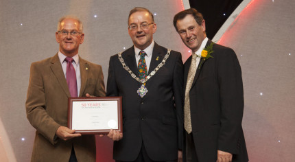 Three males holding certificate.