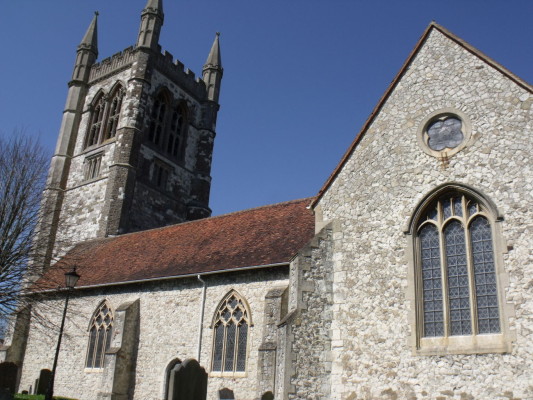 Stone church with red tiled roof. Tower, arched windows