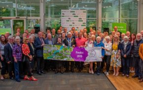 Large group of people holding a Farnham in Bloom banner