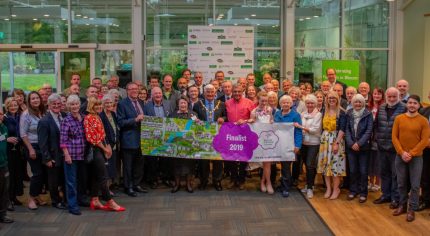 Large group of people holding a Farnham in Bloom banner