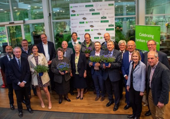 Group of people. Some holding pot plants.