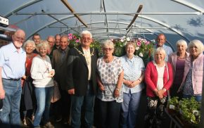 Mayor and a group of people standing inside a large poly tunnel