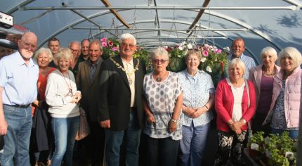 Mayor and a group of people standing inside a large poly tunnel