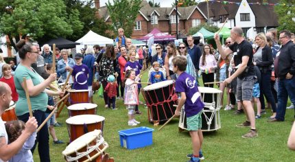 Taiko drummers watched by a crowd of people