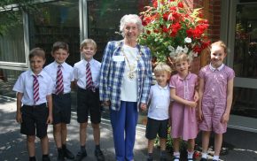 School children with the Mayor of Farnham in front of a hanging basket.