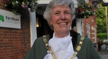 Head and shoulders of female Mayor dressed in green Mayoral robes and chain.