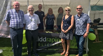 Group of people standing in front of a small marquee.