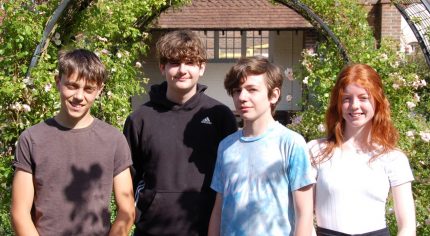 Four young people in a garden.