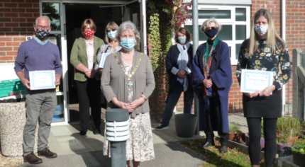 Group of people wearing masks and socially distancing.